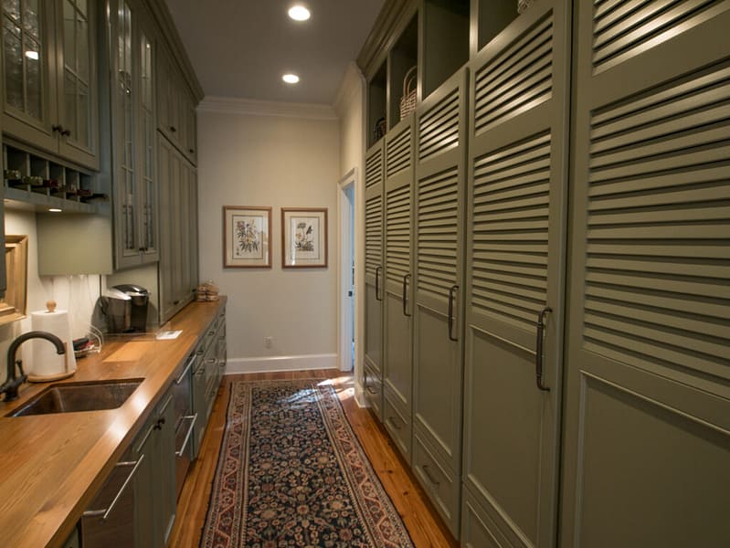 Kitchen with olive cabinets with glass doors and stainless steel finishes.